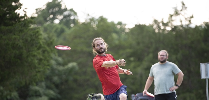 Disc golfer playing on a wooded course in Bedford County, Virginia, highlighting the county's outdoor recreation and quality of life.