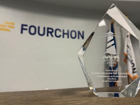 Clear glass AAPA Lighthouse Award 2024 presented to the Greater Lafourche Port Commission for excellence in environmental practices in the small port category, with the Fourchon logo in the background.