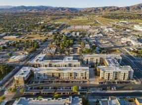 Aerial view of a suburban neighborhood with modern apartment complexes in the foreground.
