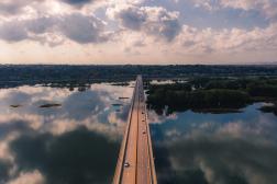 Aerial view of a bridge spanning a body of water, showcasing the structure and surrounding landscape.