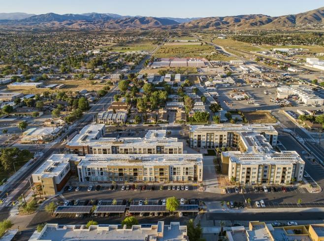 Aerial view of a suburban neighborhood with modern apartment complexes in the foreground.