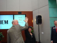 NC Commerce Secretary Keith Crisco gives IEM CEO and President Madhu Beriwal a high-five after her risk management consultng company announced in December that it is moving from Baton Rouge, LA, to Research Triangle Park, NC.