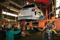 Members of United Auto Workers Local 602 install a trailer hitch on teh 2011 GMC Acadia Denali, which began production on Tuesday, September 21, 2010 at the Lansing Delta Township Assembly Plant.